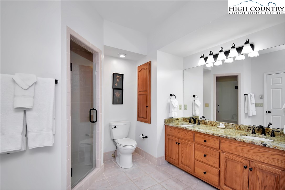 140 Manor View Lane, Unit CASCADES 2 Blowing Rock, NC 28605 - Photo 16 of 25 a spacious bathroom with a granite countertop sink a toilet and a mirror