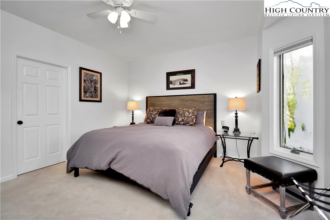 140 Manor View Lane, Unit CASCADES 2 Blowing Rock, NC 28605 - Photo 18 of 25 a bedroom with a bed a desk and chair with a mirror