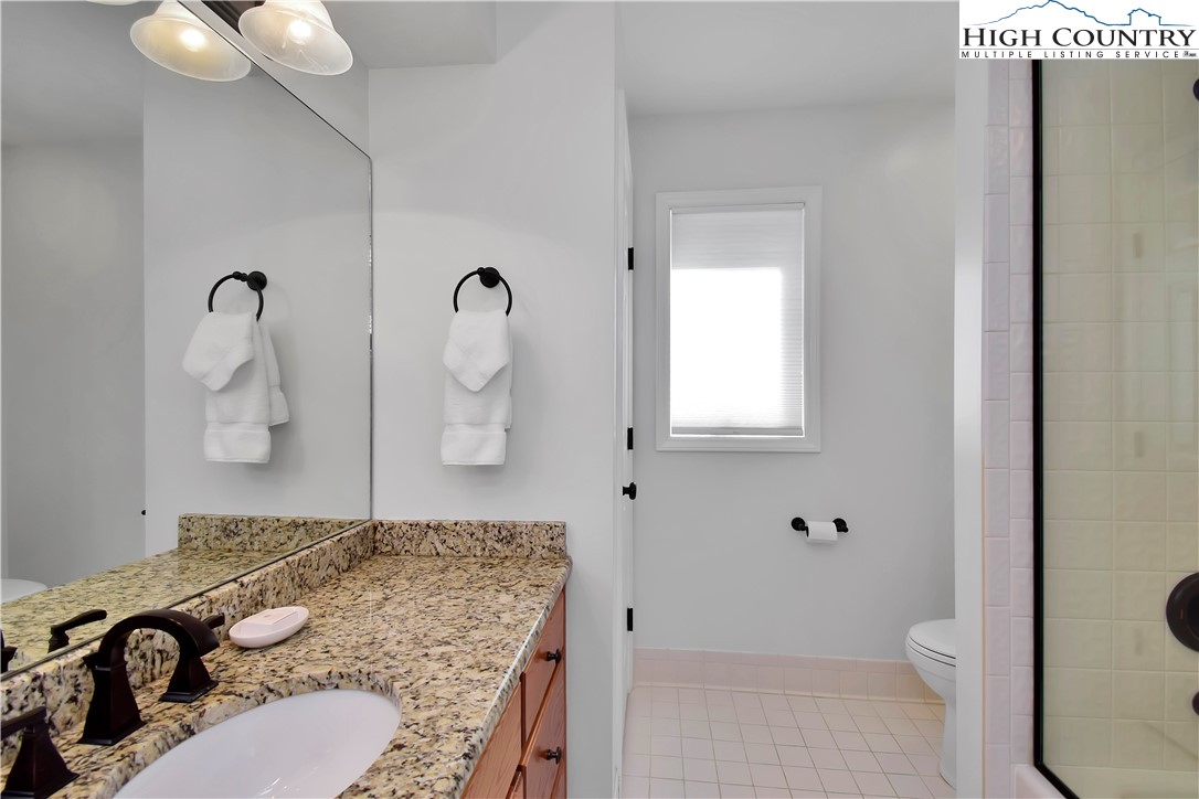 140 Manor View Lane, Unit CASCADES 2 Blowing Rock, NC 28605 - Photo 7 of 25 a bathroom with a granite countertop sink and a mirror