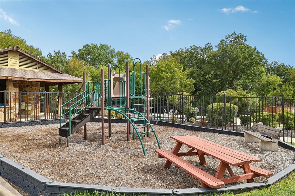 101 Ravinia Court Oak Point, TX 75068 - Photo 23 of 23 Recreational area featuring a playground structure with slides and stairs, a picnic table, and a built-in stone bench