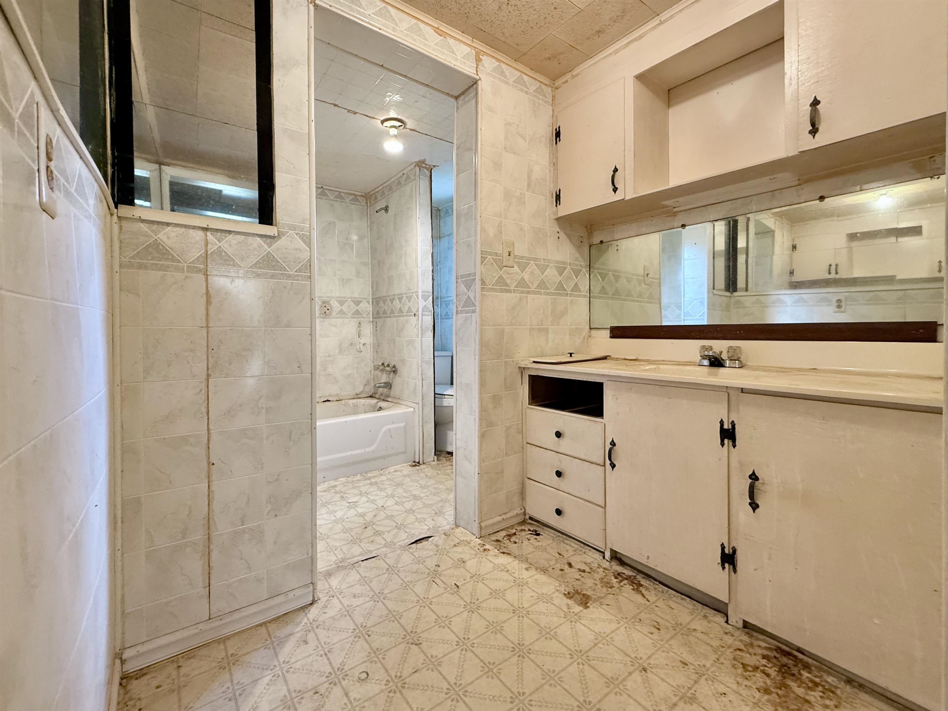 845 Needham Road Drummonds, TN 38023 - Photo 14 of 22 Bathroom featuring tile walls, vanity, light floors, and shower / tub combination