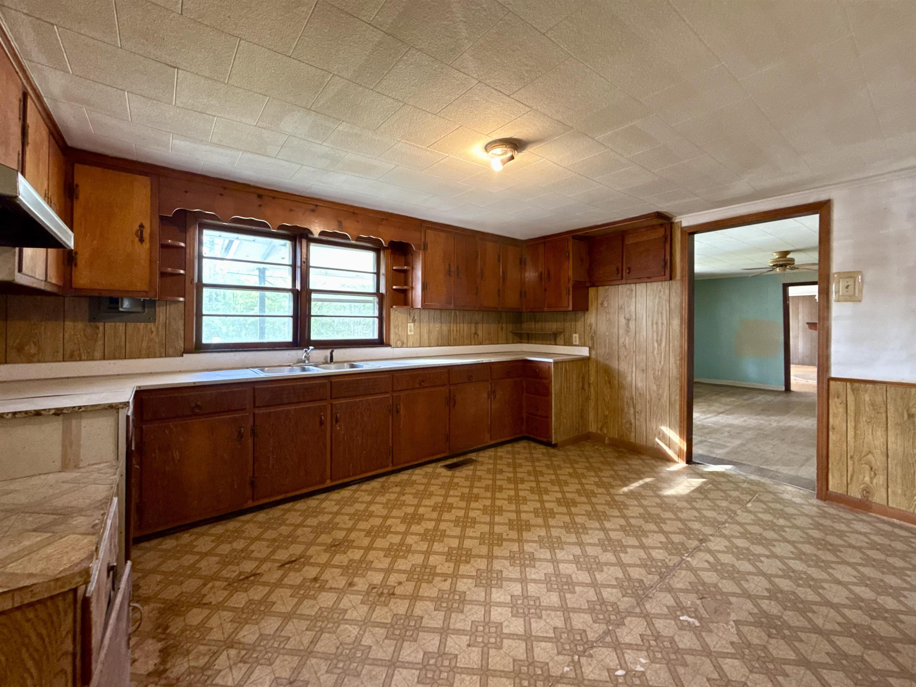 845 Needham Road Drummonds, TN 38023 - Photo 18 of 22 Kitchen featuring wooden walls, light countertops, light floors, wood finish cabinetry, and open shelves