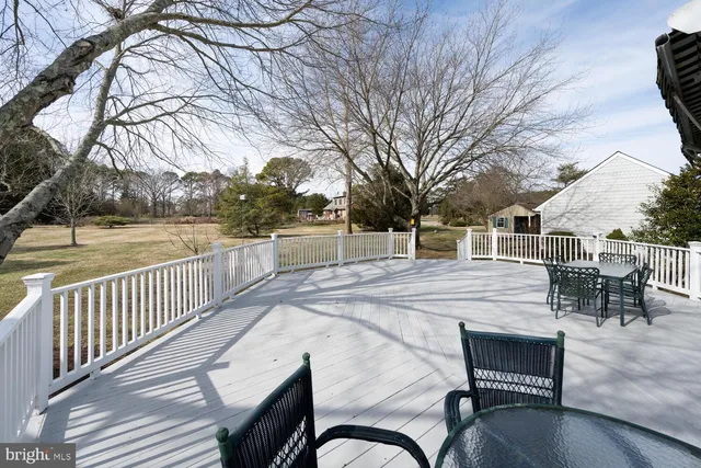 a view of a patio with table and chairs with wooden floor and fence