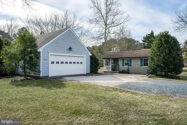 a view of a house with a yard and large tree