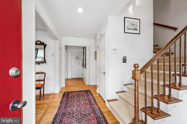 a view of a hallway with wooden floor and stairs