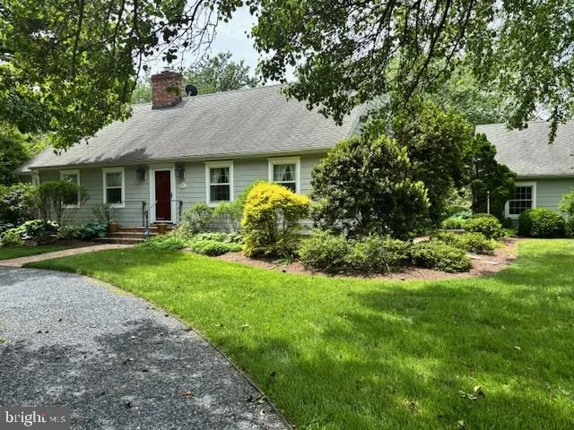 a front view of a house with a yard and trees