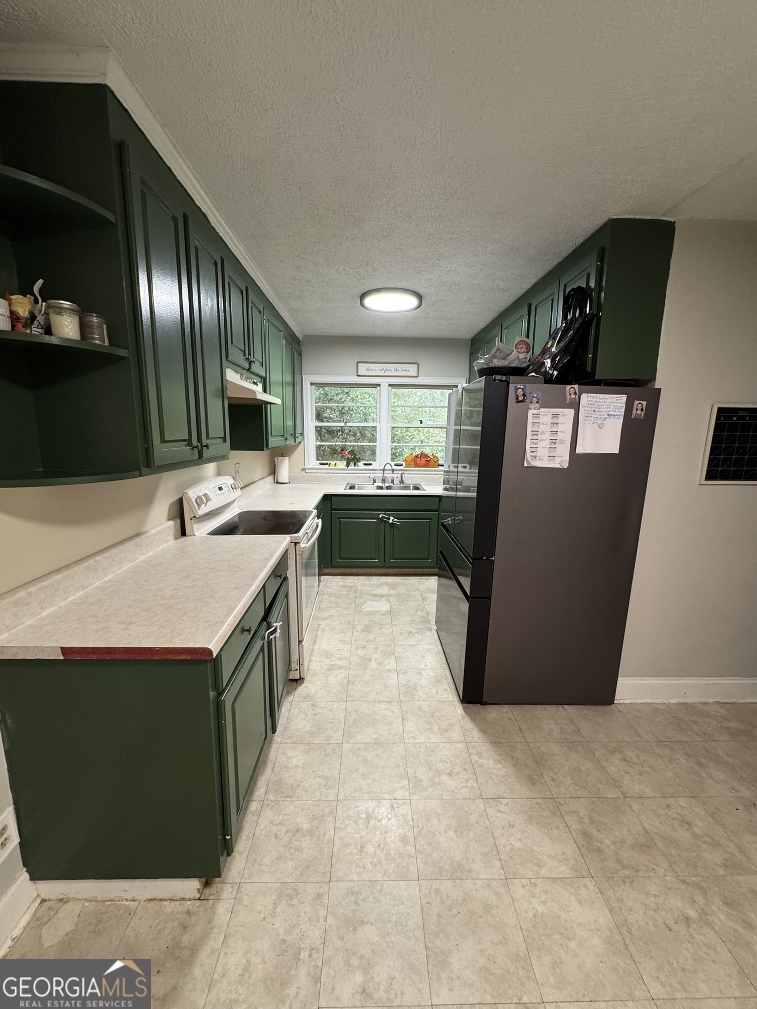 107 Springdale Drive Thomaston, GA 30286 - Photo 12 of 30 a kitchen with kitchen island a counter top space a sink a stove and a refrigerator