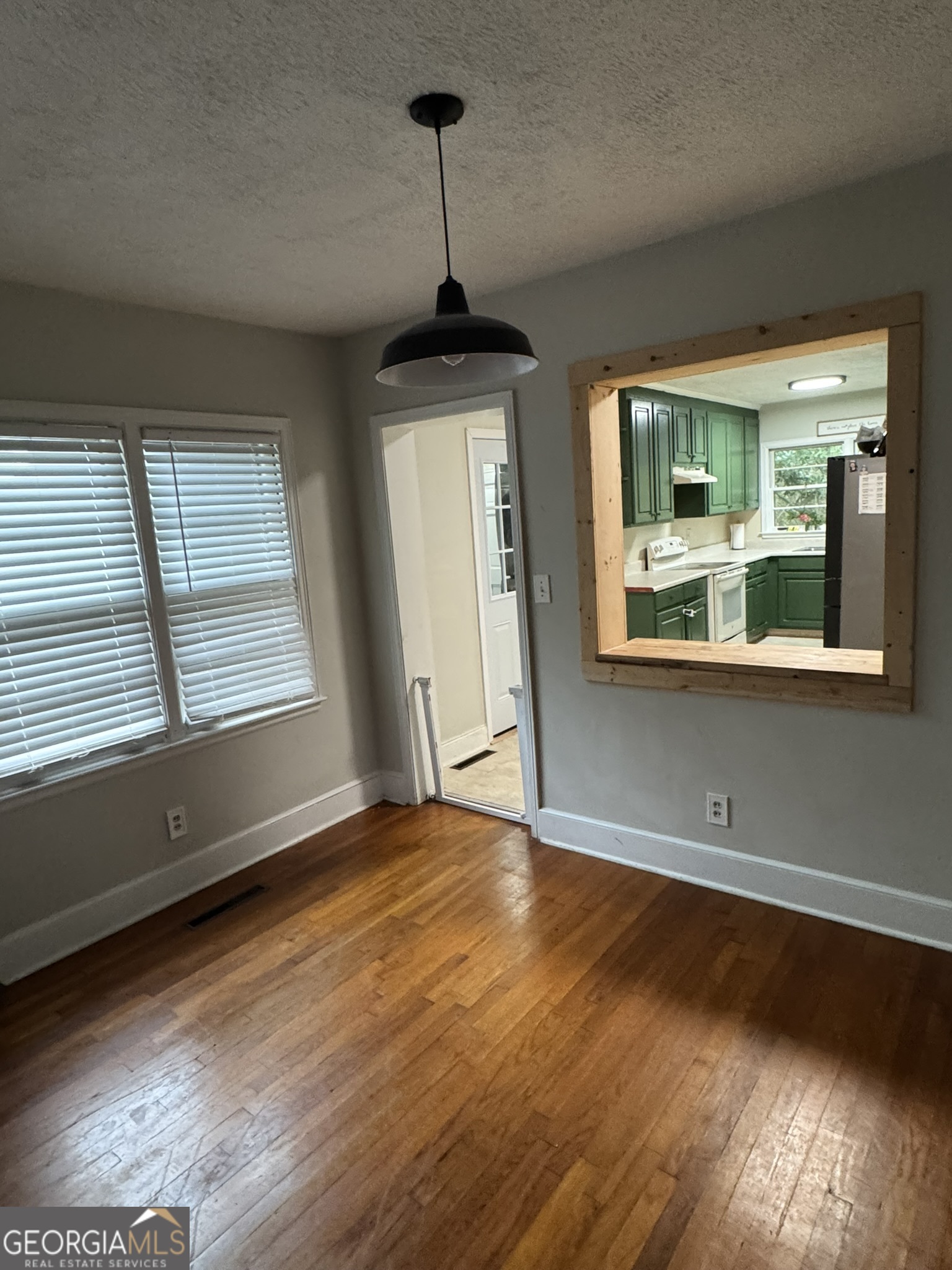 107 Springdale Drive Thomaston, GA 30286 - Photo 19 of 30 a view of an empty room with wooden floor and a window