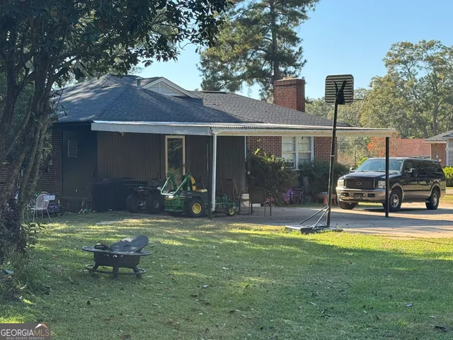 a view of a house with backyard and sitting area