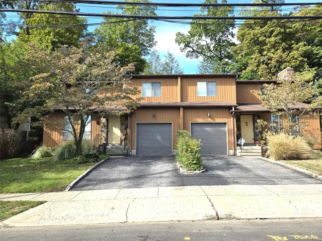 a front view of a house with a yard and a garage