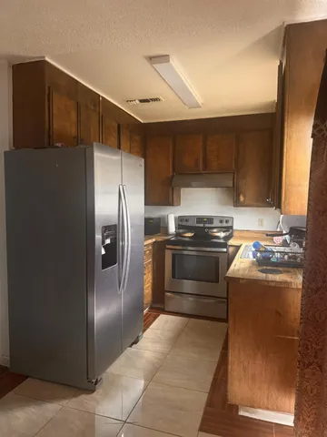 a kitchen with granite countertop a refrigerator and a stove