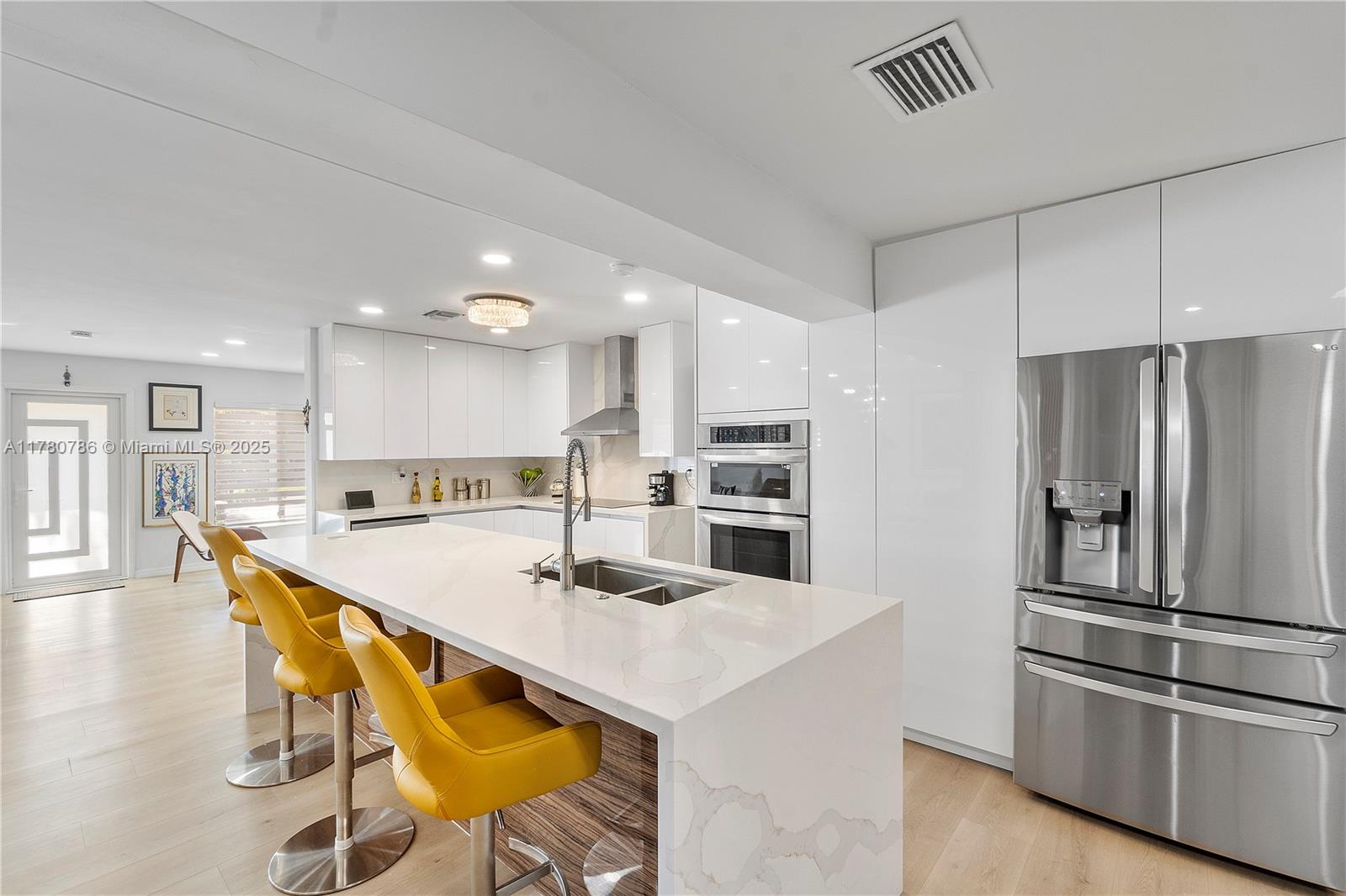 12555 Southwest 31st Street Miami, FL 33175 - Photo 15 of 47 a kitchen with stainless steel appliances kitchen island granite countertop a refrigerator a stove a sink and a dining table with wooden floor