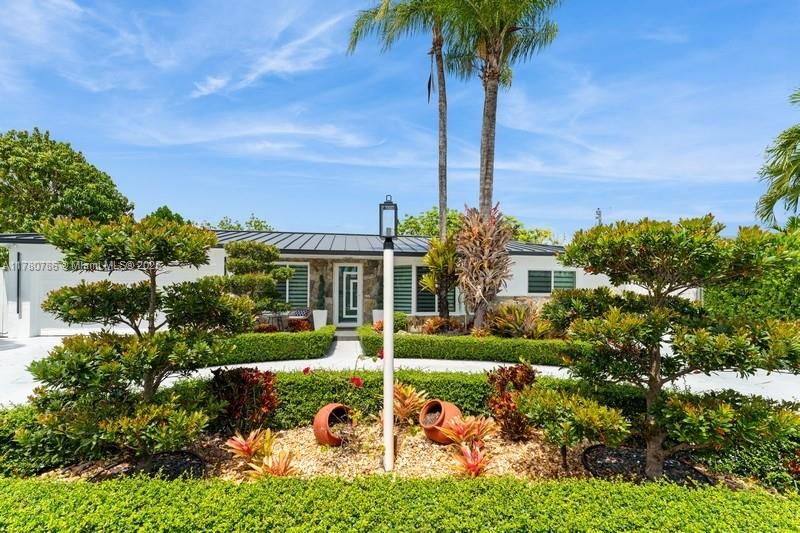 12555 Southwest 31st Street Miami, FL 33175 - Photo 2 of 47 a front view of a house with garden and trees