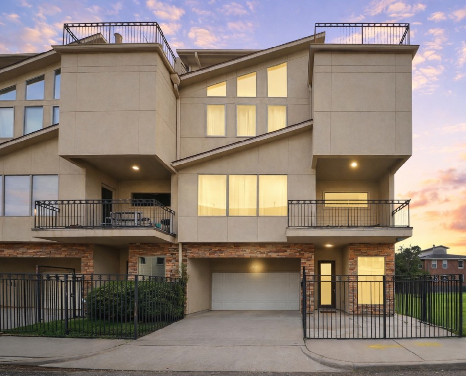 Modern multi-story townhouse showcasing a sleek stucco exterior, expansive windows that fill the home with natural light, and multiple balconies ideal for outdoor living.
