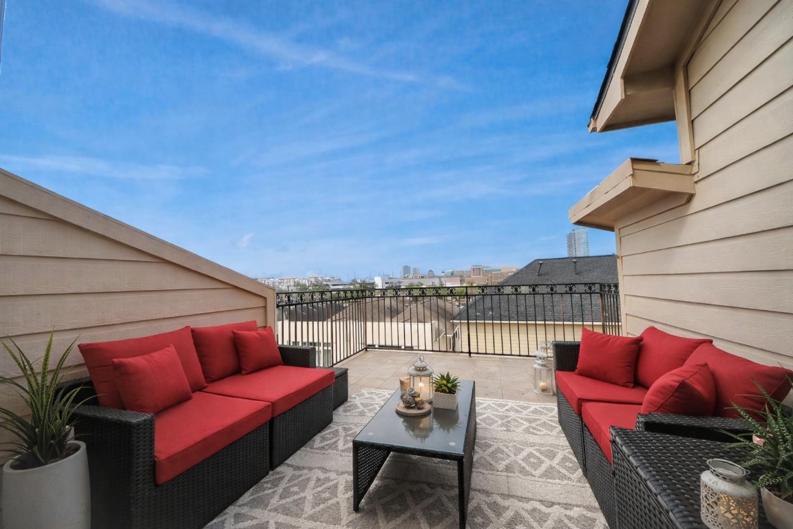 3507 Jackson Street Houston, TX 77004 - Photo 4 of 29 Rooftop terrace with tiled flooring, offering expansive cityscape views under a clear blue sky. Ideal for outdoor relaxation and entertaining. *virtually staged*