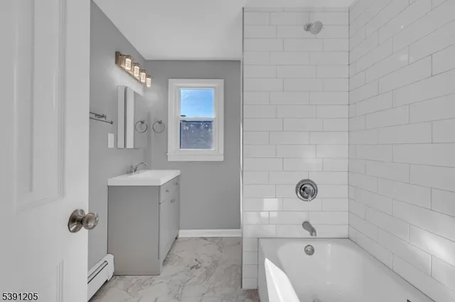 a bathroom with a tub sink and mirror