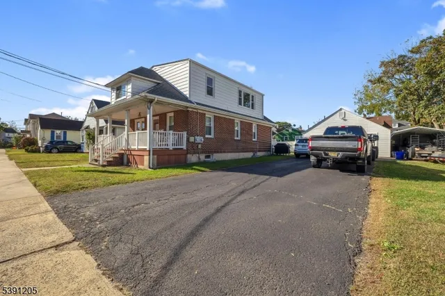 a front view of a house with a garden and trees
