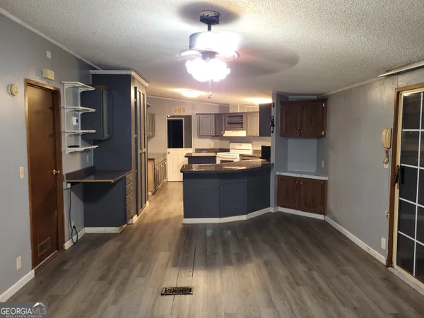 a kitchen with wooden floors appliances and cabinets