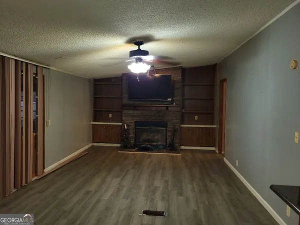 a view of a livingroom with a fireplace a chandelier and wooden floor
