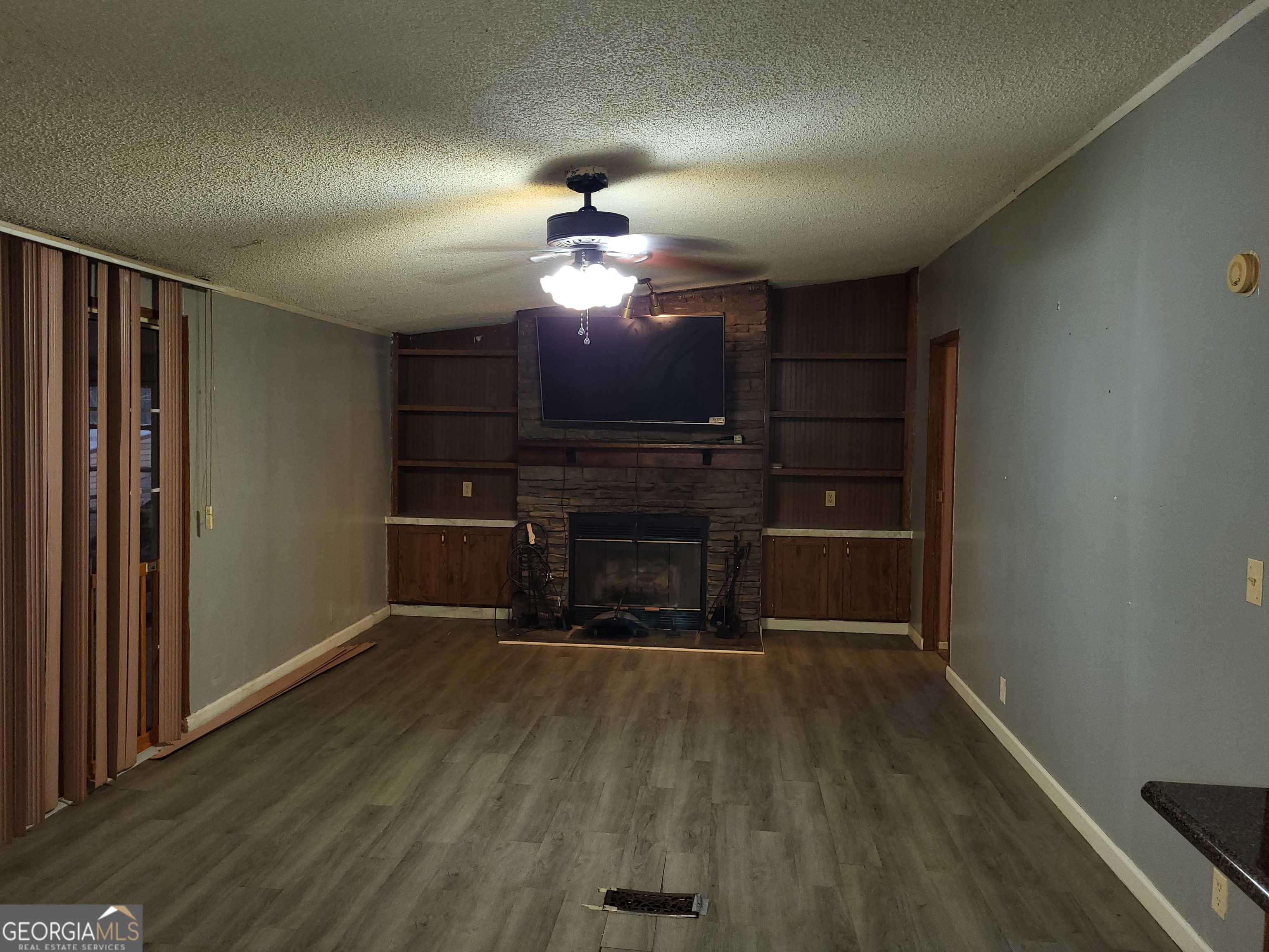 8449 Lee Road Salem, AL 36874 - Photo 14 of 26 a view of a livingroom with a fireplace a chandelier and wooden floor