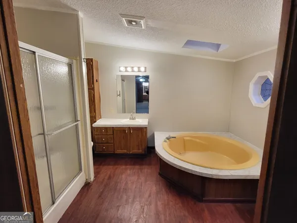 a bathroom with a tub sink and mirror