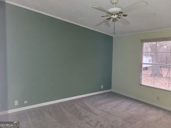 an empty room with a window and a fan