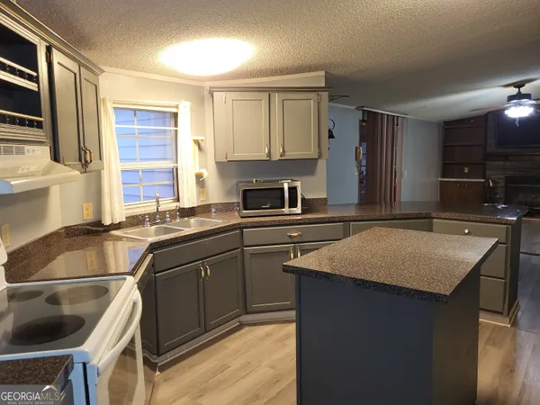 a kitchen with a sink stove and cabinets