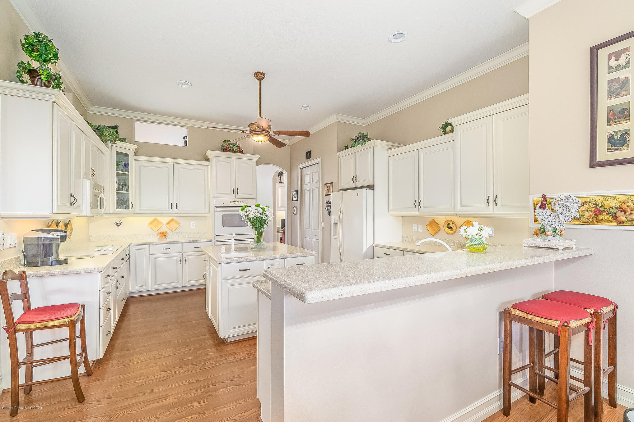 4135 Hammock Road Mims, FL 32754 - Photo 14 of 42 a kitchen with a dining table chairs sink and white cabinets