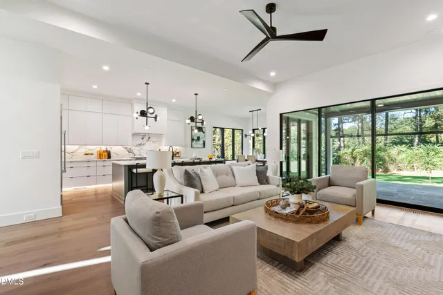 a living room with furniture chandelier and a large window