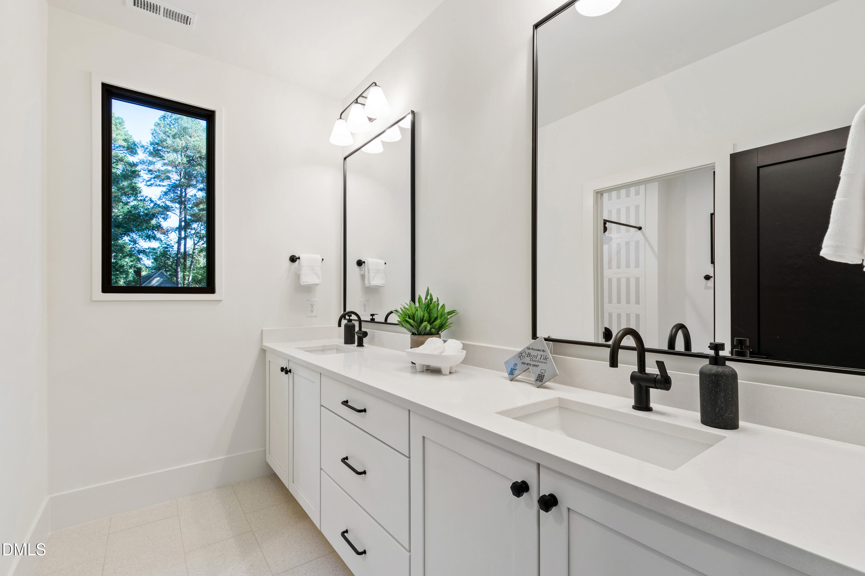 7809 Haymarket Lane Raleigh, NC 27615 - Photo 44 of 62 a bathroom with a double vanity sink and mirror
