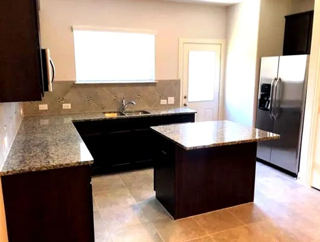 a kitchen with a sink and a large mirror