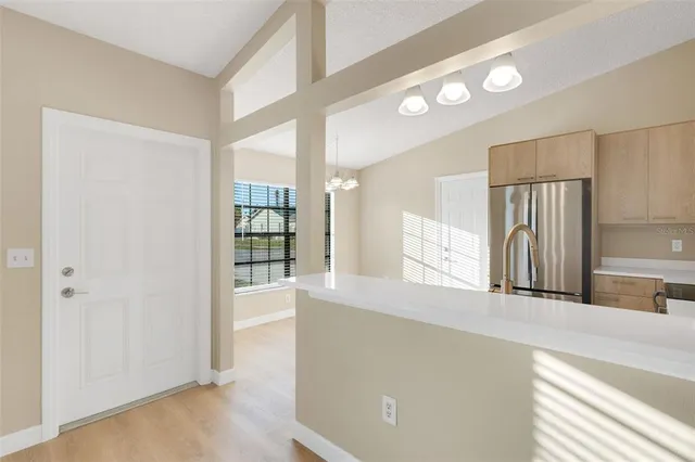 a view of a kitchen with a refrigerator a sink and a large window