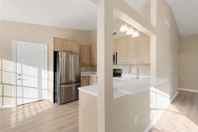 a kitchen with stainless steel appliances granite countertop a refrigerator and a sink