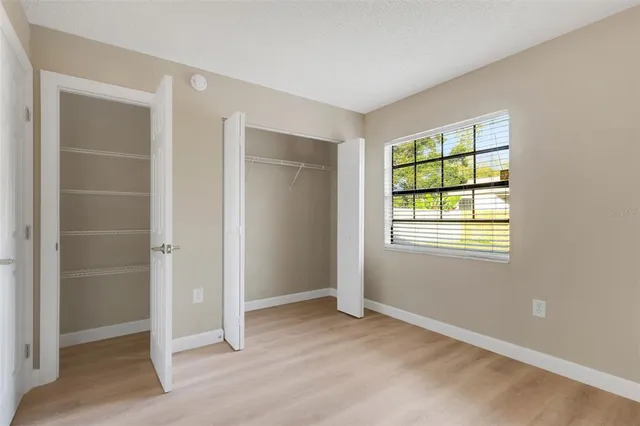 an empty room with windows and closet