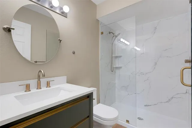 a bathroom with a sink a toilet and shower