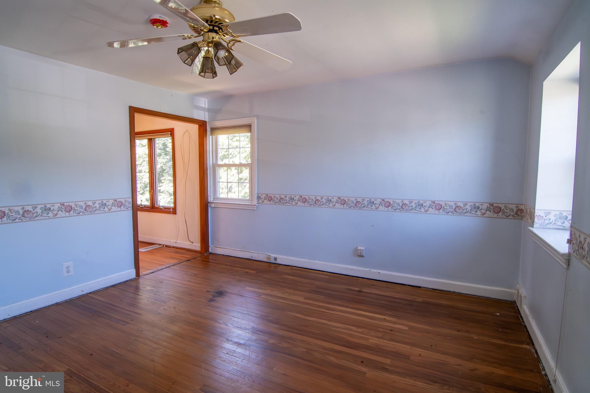 5004 Fairway Road Drexel Hill, PA 19026 - Photo 16 of 29 an empty room with wooden floor fan and windows