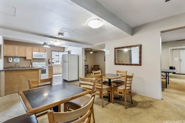 a living room with stainless steel appliances kitchen island a table and chairs in it