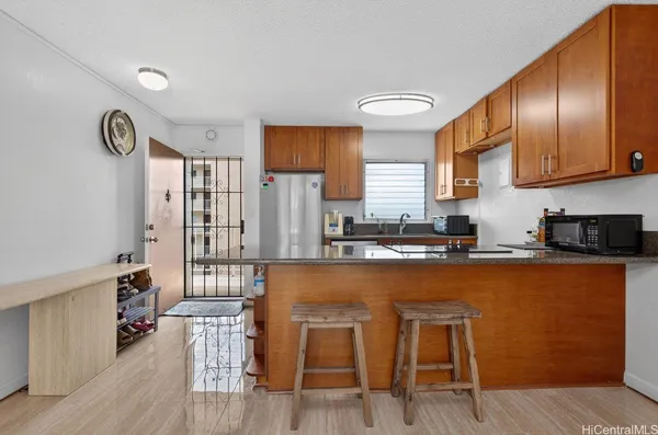 a kitchen with stainless steel appliances granite countertop a refrigerator a stove top oven a sink and dishwasher