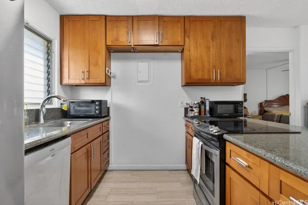a kitchen with stainless steel appliances granite countertop a stove a sink dishwasher and a refrigerator