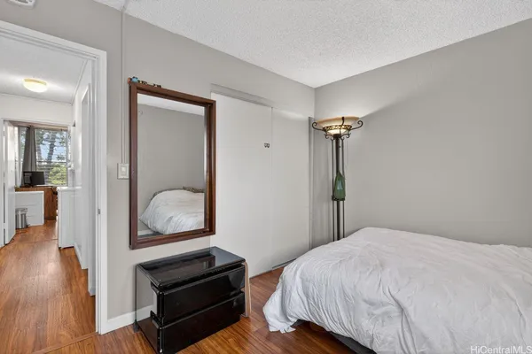 a bedroom with a bed and wooden floor