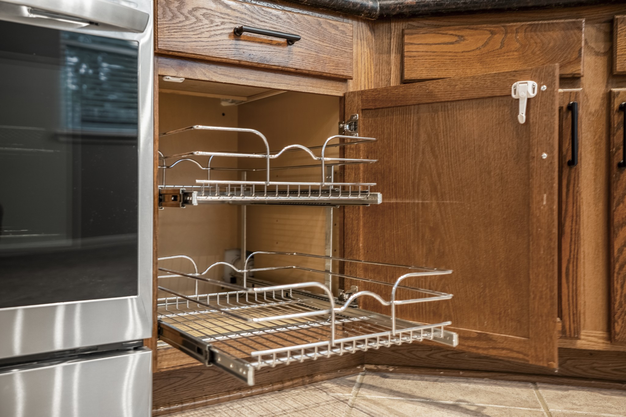 6311 Sparrows Glen Lane Spring, TX 77379 - Photo 9 of 50 Small details matter in a kitchen, and this pull-out cabinet storage beside the stove keeps everyday essentials easy to reach while maintaining the clean flow of the workspace.