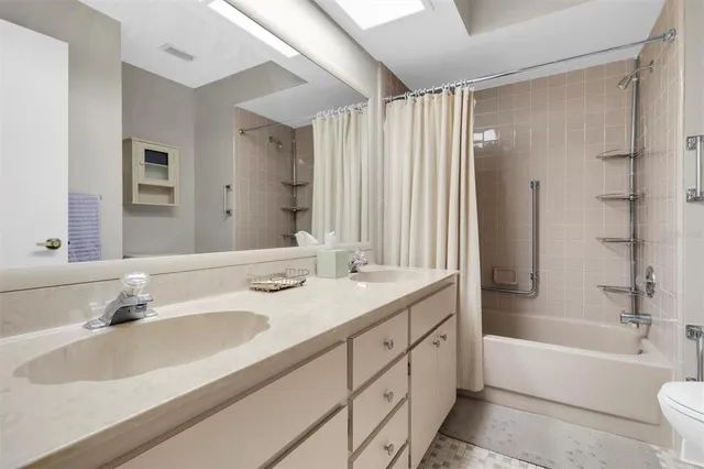 a bathroom with a sink double vanity mirror and a bathtub