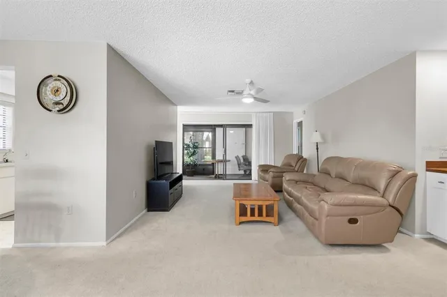 a living room with furniture a clock on wall and a window