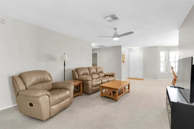 a living room with furniture and a ceiling fan