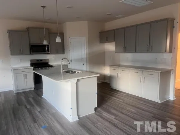 a kitchen with granite countertop a sink and a stove top oven