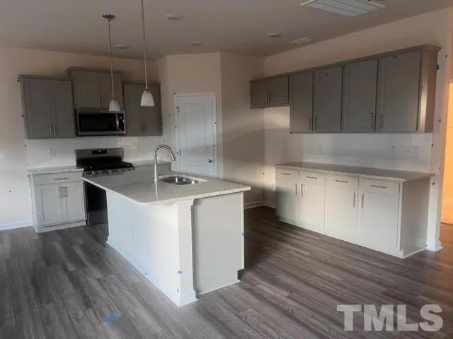 a kitchen with granite countertop a sink and a stove top oven
