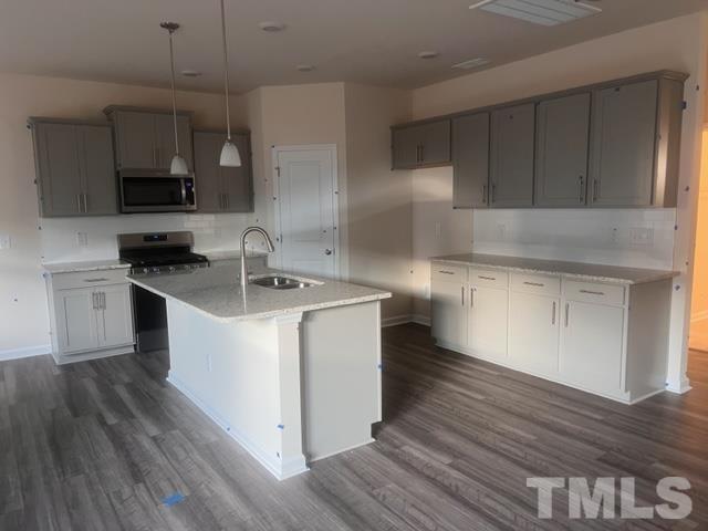 128 Katrine Way Raleigh, NC 27603 - Photo 4 of 19 a kitchen with granite countertop a sink and a stove top oven