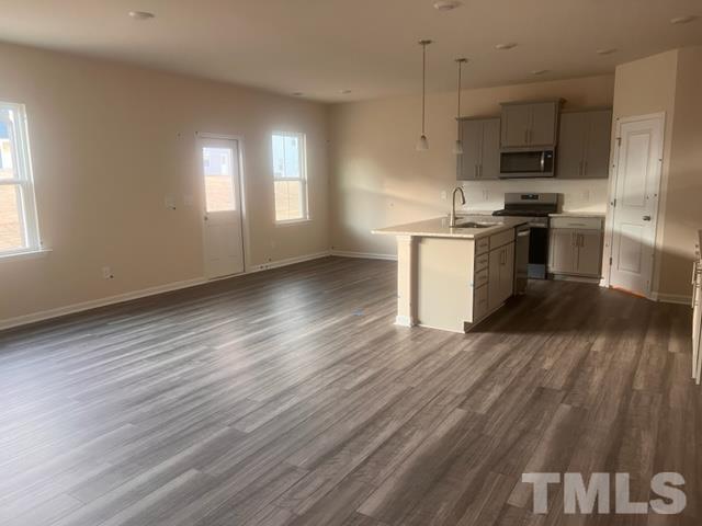 128 Katrine Way Raleigh, NC 27603 - Photo 5 of 19 a kitchen with granite countertop a stove a sink and a refrigerator