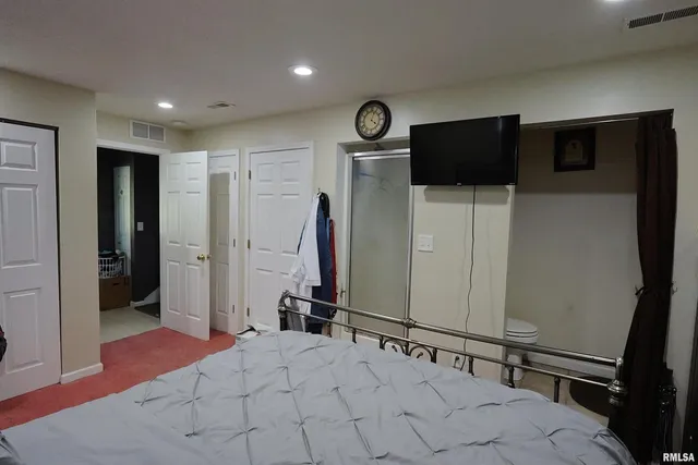 a spacious bedroom with a bed and a large mirror