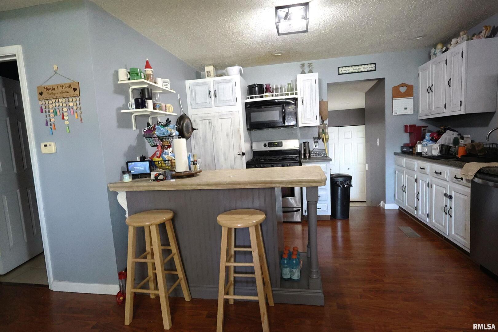 290 West 3rd Street Bonnie, IL 62816 - Photo 7 of 28 a kitchen with stainless steel appliances a dining table chairs and wooden floor